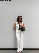 A woman wearing white high-waisted pants